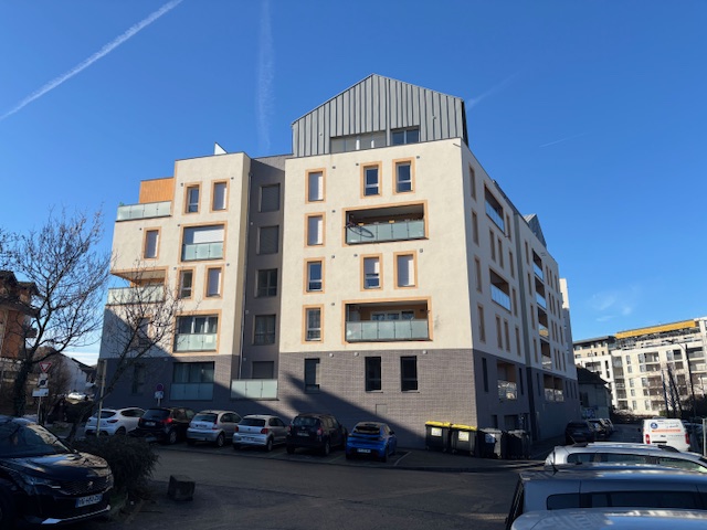 Immeuble moderne avec façades en béton et grandes fenêtres, rue de la ville.