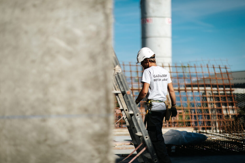 Ouvrier BTP montant une échelle sur chantier