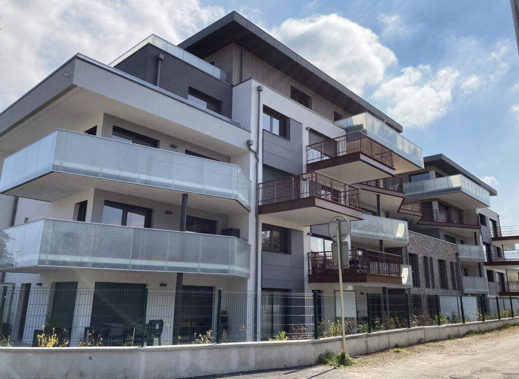 Résidence moderne avec balcons en verre et clôture