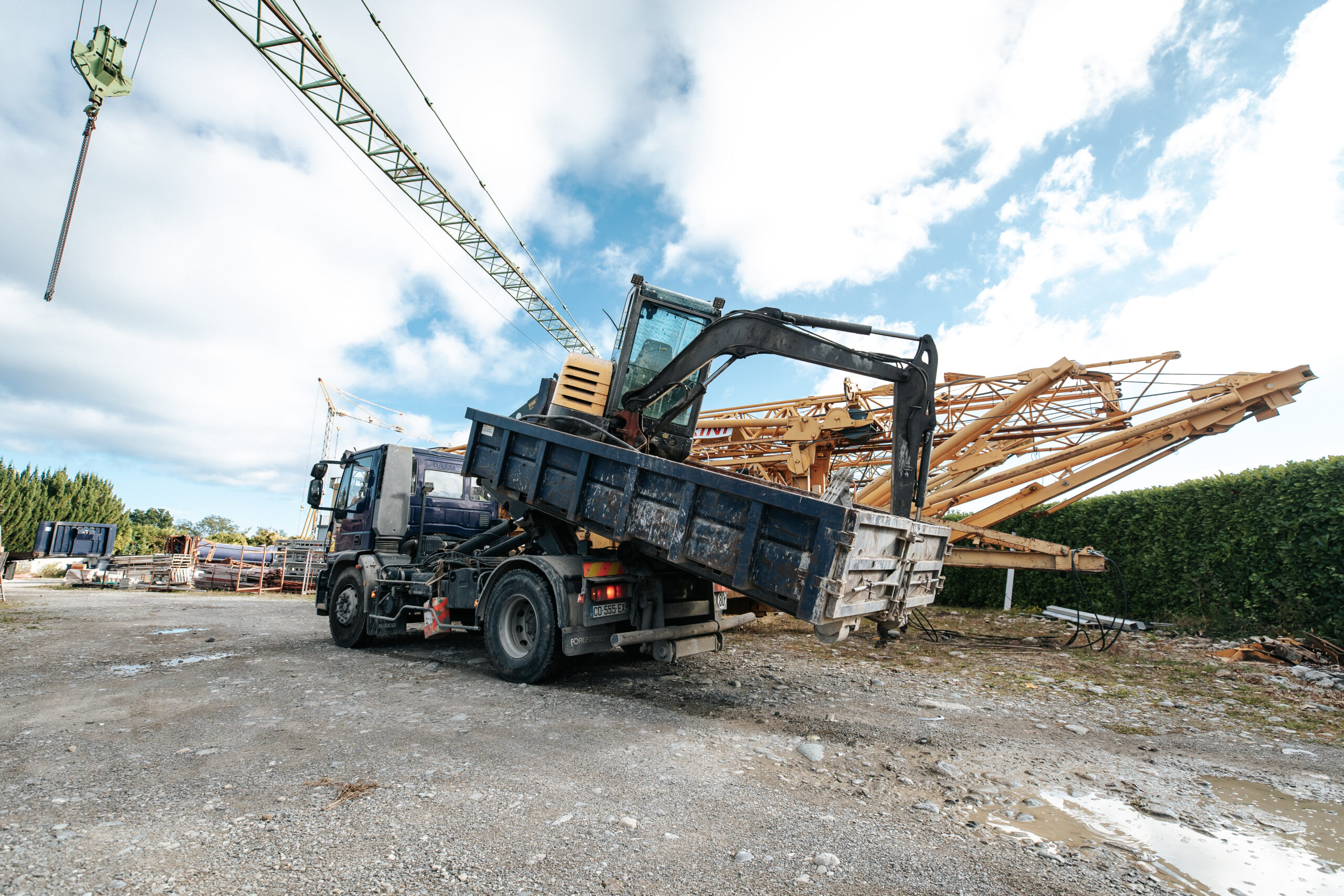 Chariot grue déchargeant des poutres sur chantier