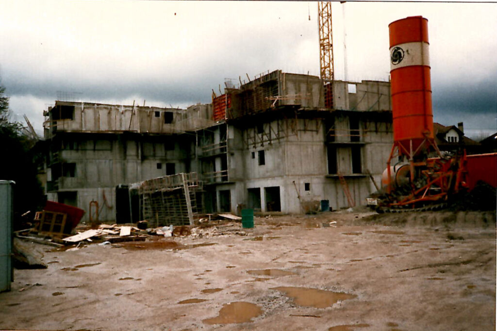 Construction de bâtiment en cours avec bétonnière sur chantier.