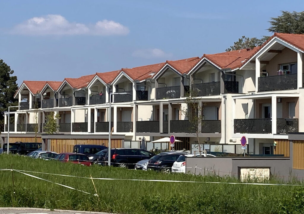 Résidence avec balcons et voitures garées