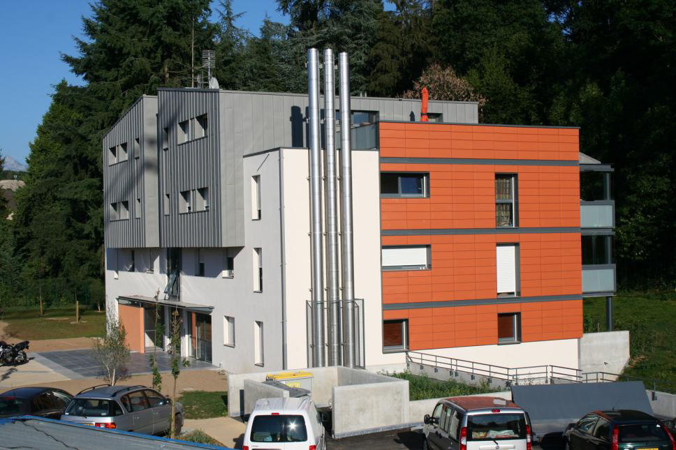 Immeuble résidentiel avec façade orange et blanche, construction moderne.